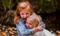 Young girl hugging her little sister Teach kindness and relationships will grow